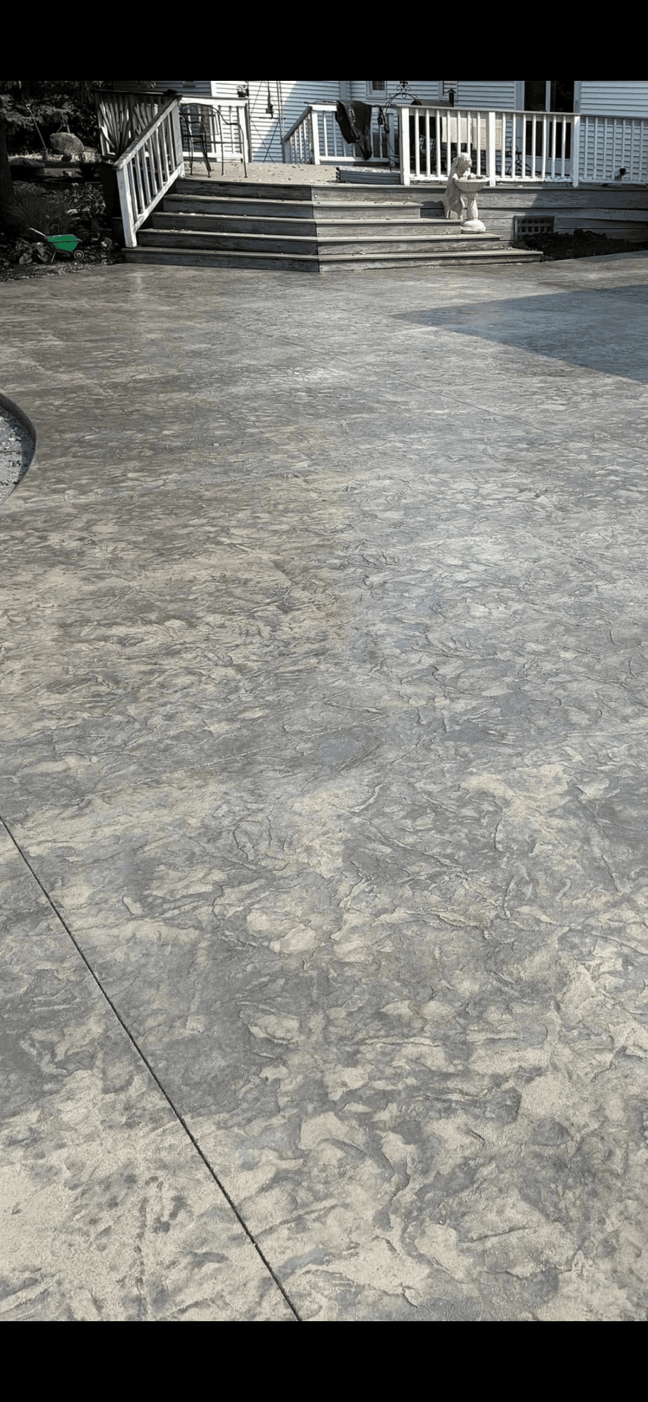 Stamped concrete patio with deck stairs by S&T Concrete